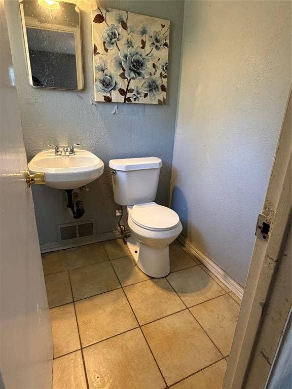Wall-mounted sink with dual-handle faucet and ceramic tile flooring