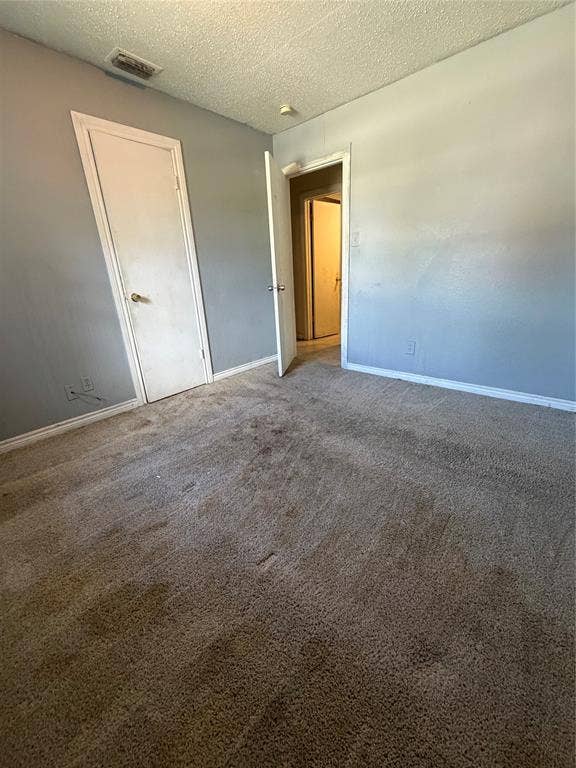 Interior space featuring neutral wall paint, carpeted flooring, and two interior doors