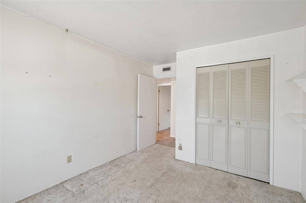 3309 S Edelweiss Drive, Grand Prairie, TX 75052 A bedroom with a full louvered closet.