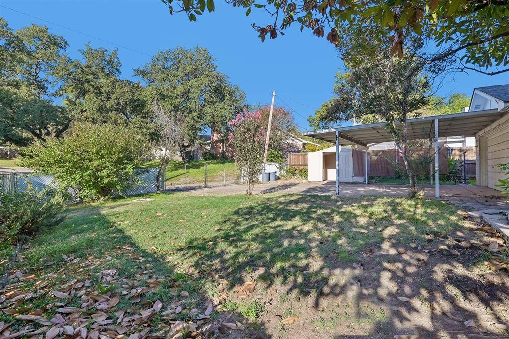 3309 S Edelweiss Drive, Grand Prairie, TX 75052 Mature trees and open lawn across the corner-lot backyard.