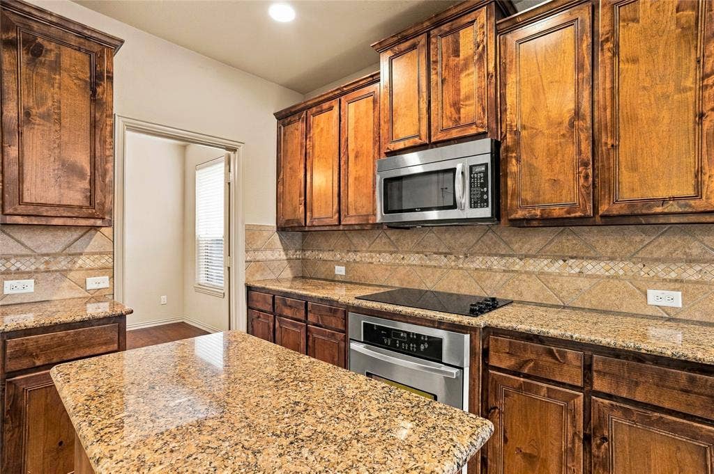 104 Aztec Court, Waxahachie, TX 75165 Granite counter tops, island, electric cooktop and oven.