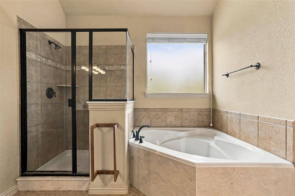 104 Aztec Court, Waxahachie, TX 75165 Primary bath has separate tub and shower with privacy window.