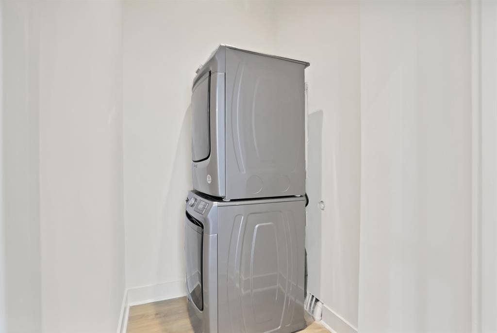 1731 N Fitzhugh Avenue, Dallas, TX 75204 Clothes washing area with stacked washing maching and dryer and light hardwood / wood-style floors