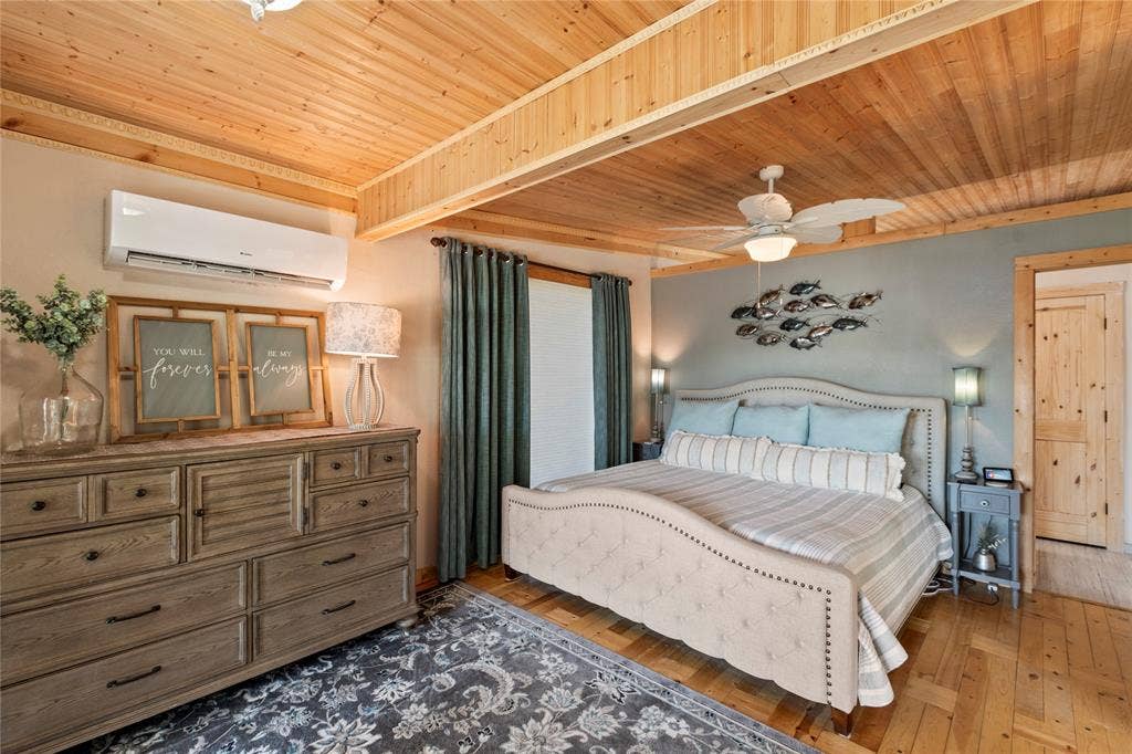 230 Bushwhacker Drive, Mabank, TX 75156 Wood-paneled ceiling with exposed beam, wood-finish flooring, wall-mounted ductless air conditioning unit, and solid wood interior door