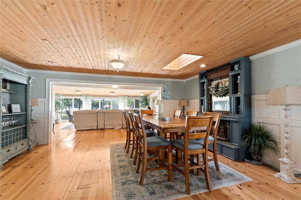 230 Bushwhacker Drive, Mabank, TX 75156 Natural wood-plank ceiling, skylight, light-toned wood-finish flooring, built-in cabinetry with integrated shelving, and white wainscoting
