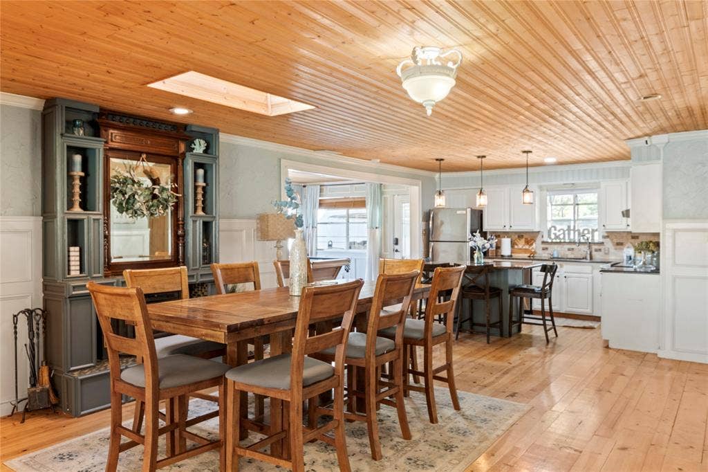 230 Bushwhacker Drive, Mabank, TX 75156 Tongue-and-groove wood ceiling featuring a built-in skylight, wood-finish flooring, custom floor-to-ceiling built-in cabinetry, and white wainscoting