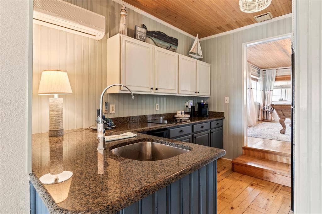 230 Bushwhacker Drive, Mabank, TX 75156 Kitchen featuring stone countertops, stainless steel undermount sink, dual-toned cabinetry, wood-finish flooring, and natural wood-plank ceiling