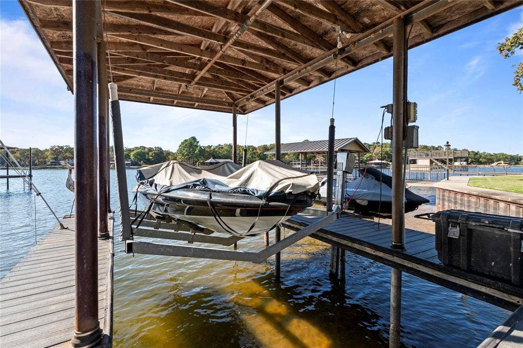 230 Bushwhacker Drive, Mabank, TX 75156 Covered boat slip featuring a heavy-duty mechanical boat lift, composite decking, and metal roofing structure