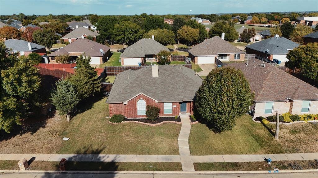 Single-story brick exterior residence featuring a composition shingle roof, arched window detail, and a concrete walkway