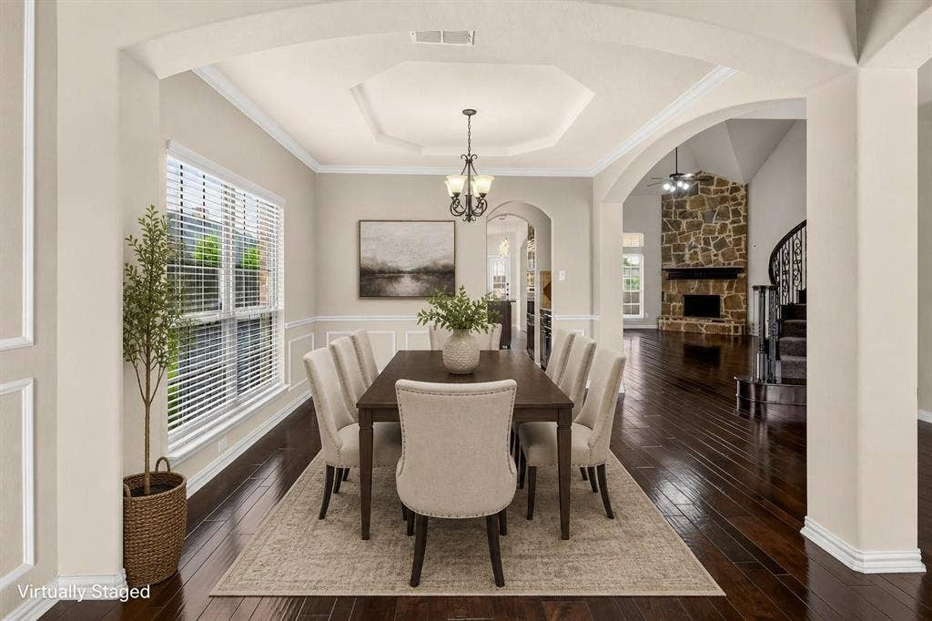 206 White Rock Court, Ovilla, TX 75154 Dining area featuring an octagonal tray ceiling, wainscoting, dark wood-finish flooring, and a multi-light chandelier