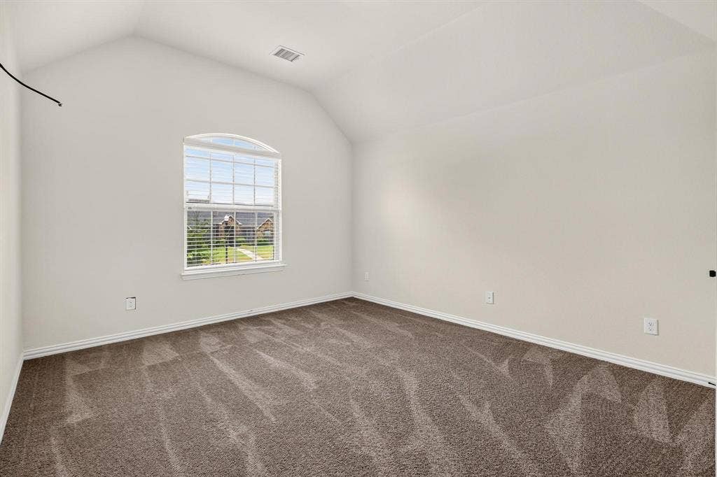 206 White Rock Court, Ovilla, TX 75154 Vaulted ceiling room featuring neutral carpeting and an arched window