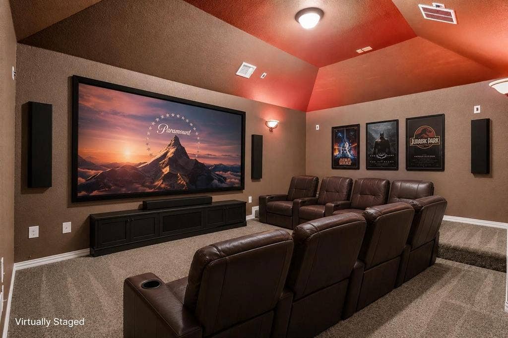 206 White Rock Court, Ovilla, TX 75154 Media room featuring a vaulted ceiling, tiered platform flooring, wall-mounted sound panels, and a built-in media console