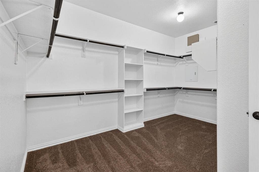 206 White Rock Court, Ovilla, TX 75154 Walk-in closet featuring tiered clothing rods, integrated shelving units, and carpeted flooring