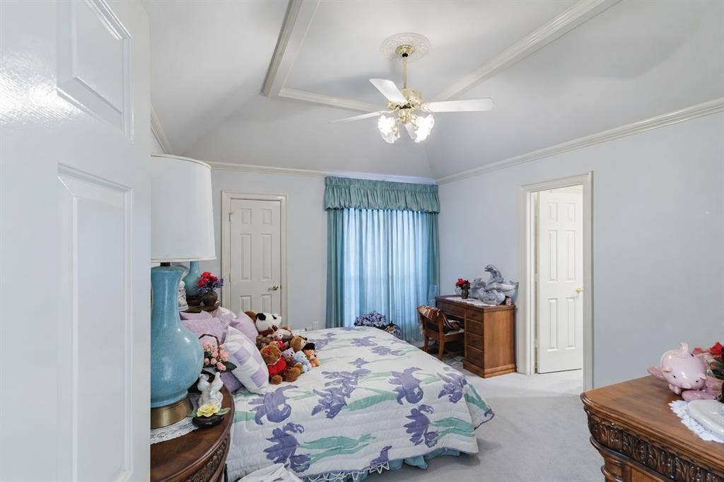 Vaulted ceiling featuring architectural tray detailing and a central ceiling fan with multi-light fixture