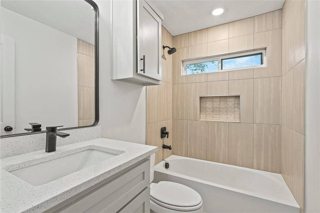 Bathroom featuring vanity, bathtub / shower combination, and toilet
