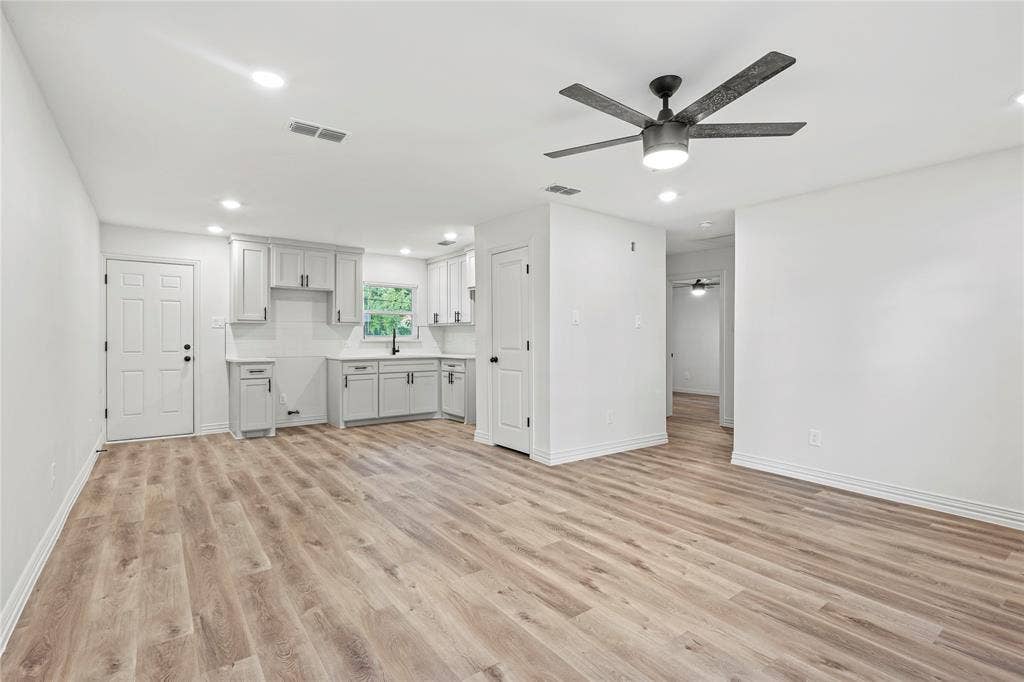 Unfurnished living room with ceiling fan, light wood-style floors, baseboards, and recessed lighting