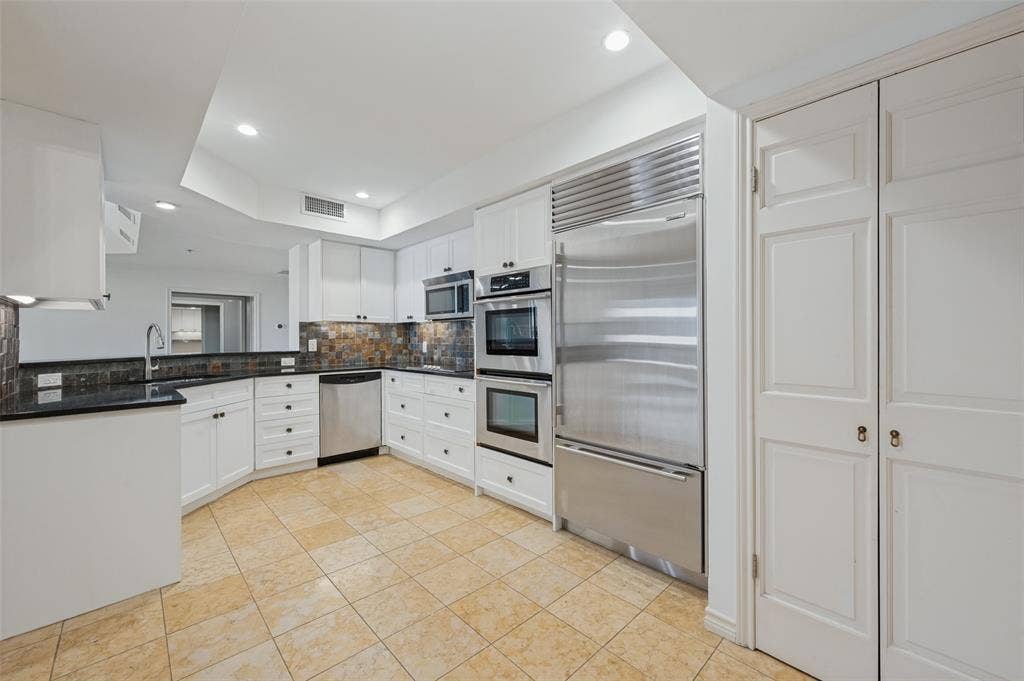 Kitchen featuring white cabinetry, granite countertops  , tile backsplash, SS appliances