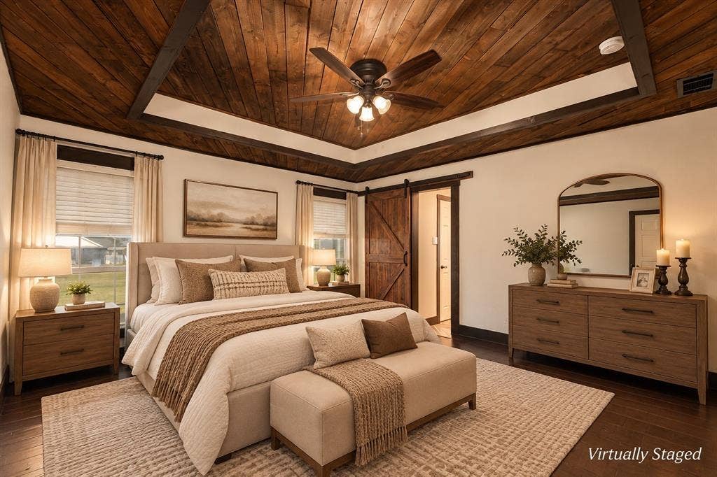 1158 County Road 141, Kaufman, TX 75142 Tray ceiling with natural wood-finish planking, dark timber crown molding, integrated ceiling fan, and sliding barn-style door