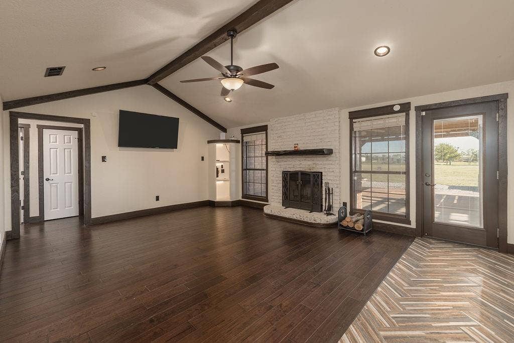 1158 County Road 141, Kaufman, TX 75142 Vaulted ceiling with exposed wood beams and a brick fireplace