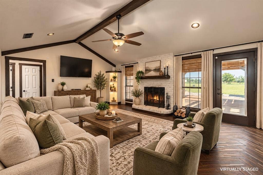 1158 County Road 141, Kaufman, TX 75142 Vaulted ceiling featuring exposed beams, masonry fireplace with a wood mantel, wood-finish flooring, and built-in corner cabinetry with integrated lighting