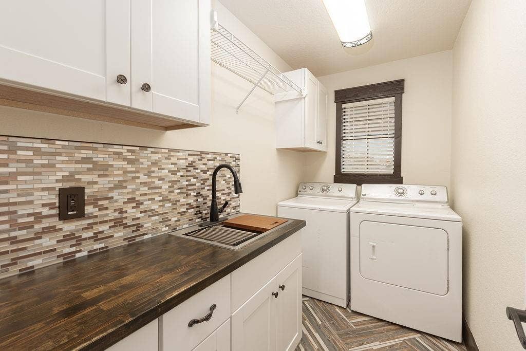 1158 County Road 141, Kaufman, TX 75142 Laundry room with cabinets, a sink and a hanging area.