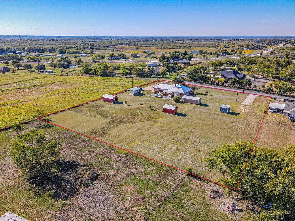 1158 County Road 141, Kaufman, TX 75142 Expansive acreage featuring a main residence, multiple detached storage structures, and open green space