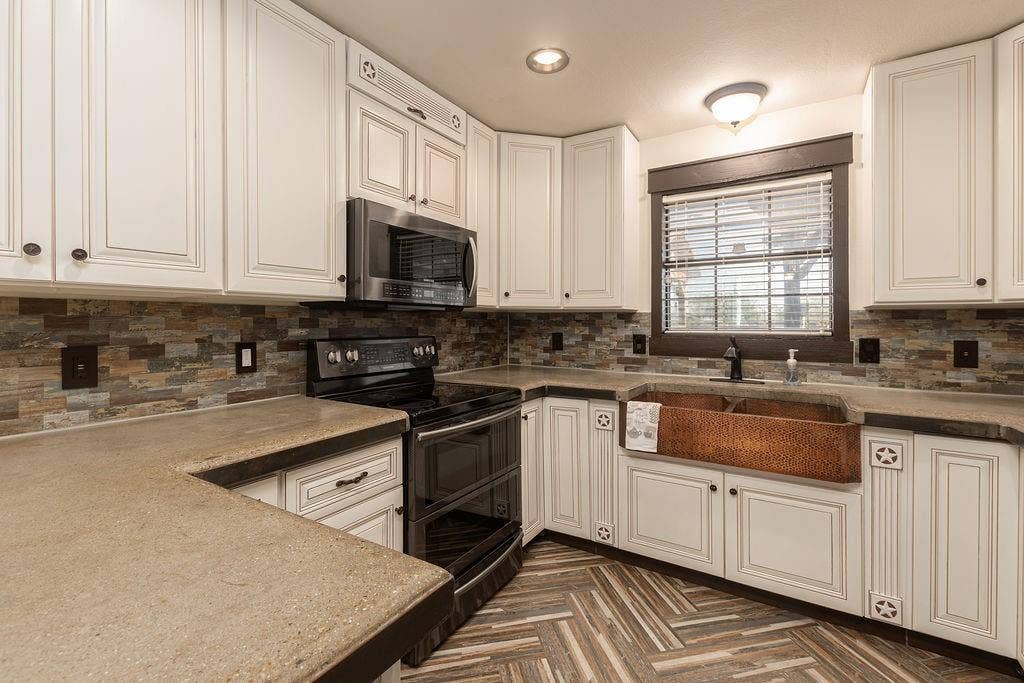 1158 County Road 141, Kaufman, TX 75142 Kitchen featuring a hammered copper apron-front sink, an electric range and a microwave
