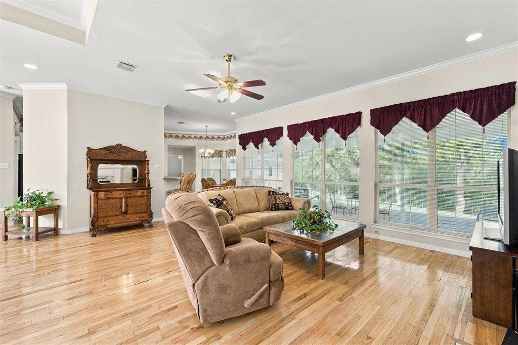 5030 Bosque Ridge Road, Crawford, TX 76638 Open-concept interior featuring light wood-finish flooring, recessed lighting, crown molding, and a central ceiling fan