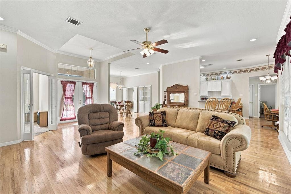 5030 Bosque Ridge Road, Crawford, TX 76638 Open-concept living space featuring wood-finish flooring, recessed lighting, double-door entryway with transom window, and ceiling fans