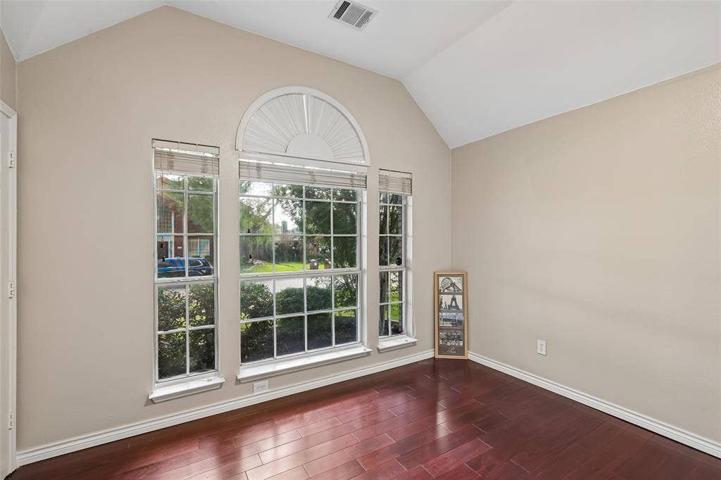3837 Pine Valley Drive, Plano, TX 75025 Vaulted ceilings, wood-finish flooring, and a large multi-pane window assembly featuring an arched transom top