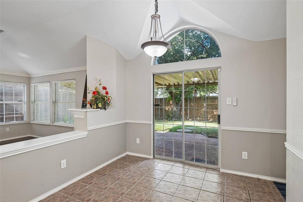 3837 Pine Valley Drive, Plano, TX 75025 Vaulted ceiling featuring an arched transom window, ceramic tile flooring, and a multi-light metal chandelier
