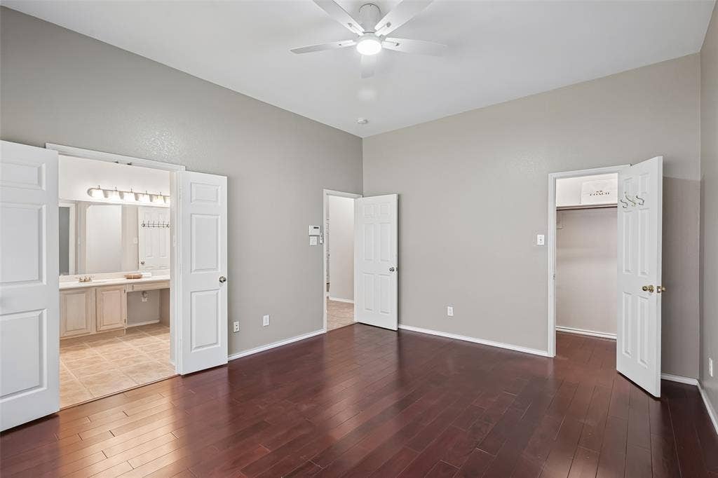 3837 Pine Valley Drive, Plano, TX 75025 Room featuring wood-finish flooring, vaulted ceilings, a ceiling fan, six-panel interior doors, and a walk-in closet