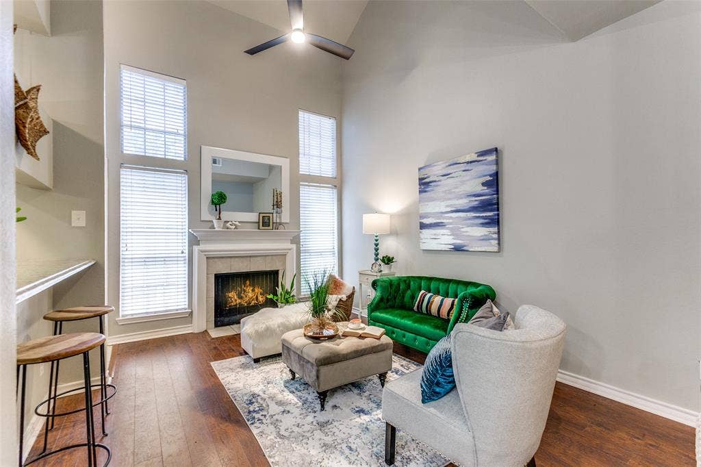 Vaulted ceilings, wood-finish flooring, fireplace with a mantel, and oversized windows