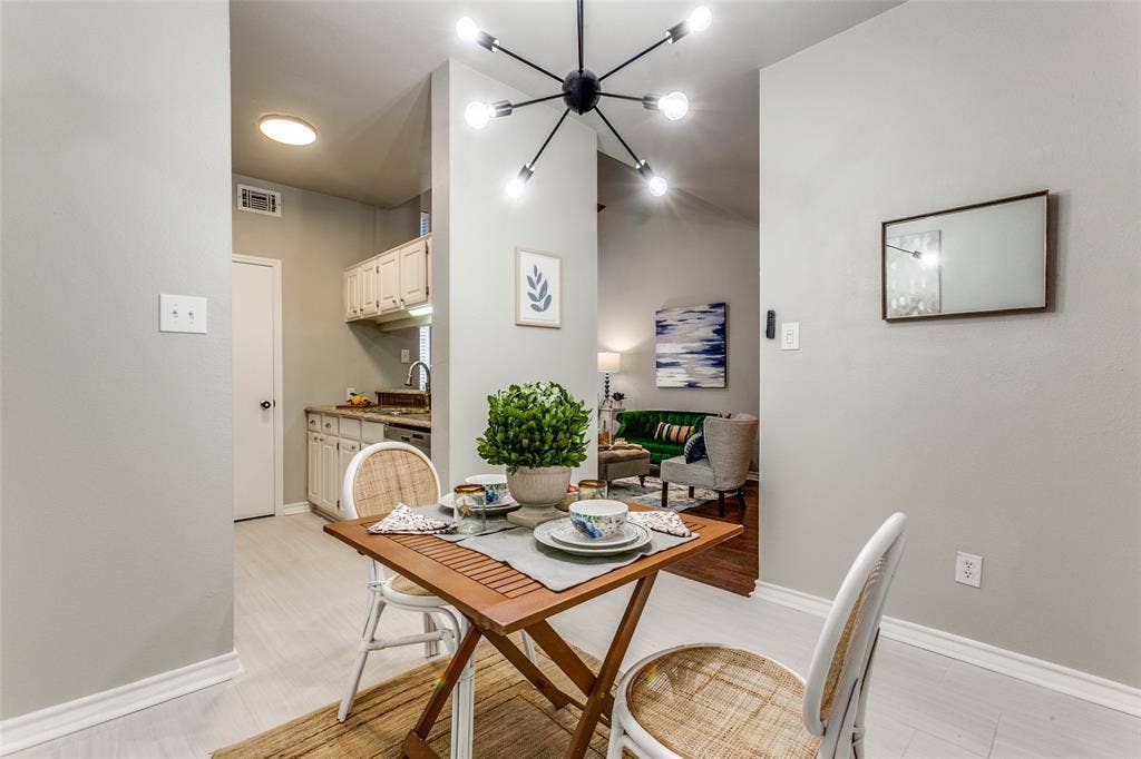 Multi-arm sputnik chandelier, white cabinetry, and light-toned flooring