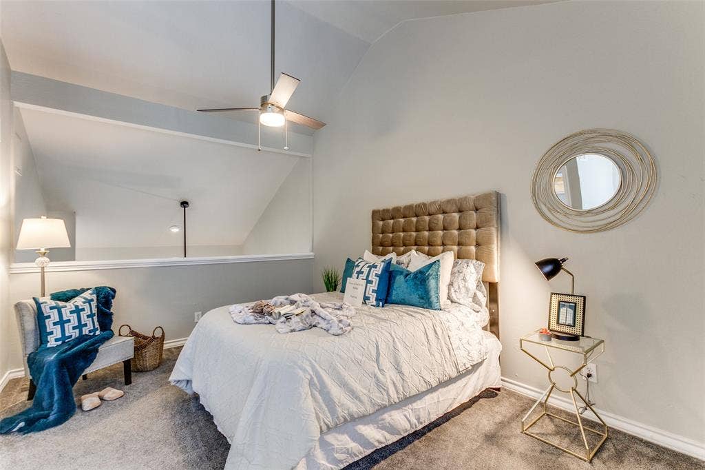 Vaulted ceiling with an integrated brushed-metal ceiling fan and a partial-wall cutout feature