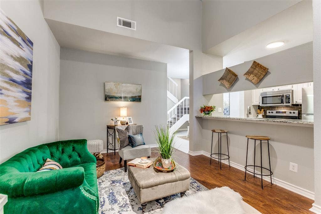 Vaulted ceilings, wood-finish flooring, and a breakfast bar with stone-patterned countertop