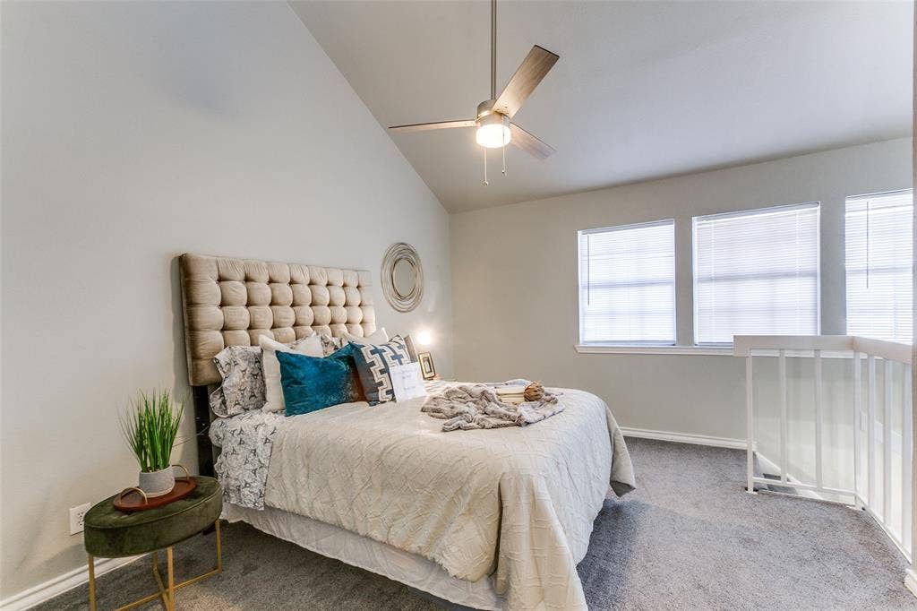 Vaulted ceilings, three paneled windows, and a ceiling fan with integrated lighting