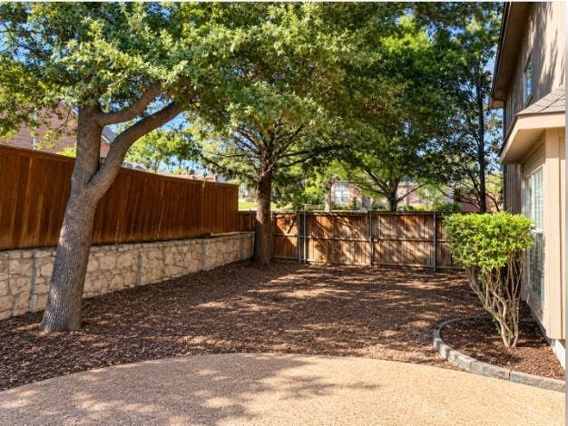 Side yard off of pool and patio- Backyard featuring wood privacy fencing, and mature trees.
