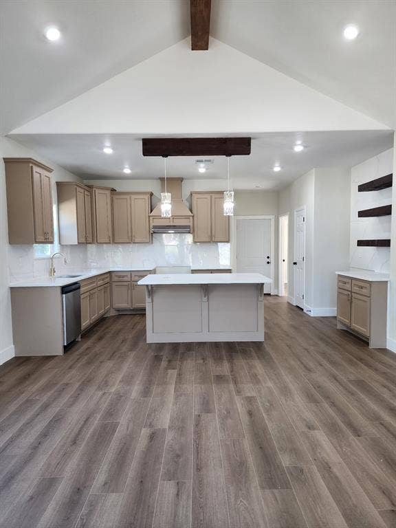 Kitchen featuring a vaulted ceiling with exposed beam, wood-finish flooring, central island with quartz countertop, shaker-style cabinetry, and recessed lighting