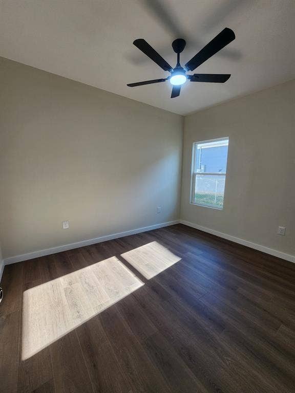 Room with wood-finish flooring, neutral wall paint, single-pane window, and a multi-blade ceiling fan with integrated lighting