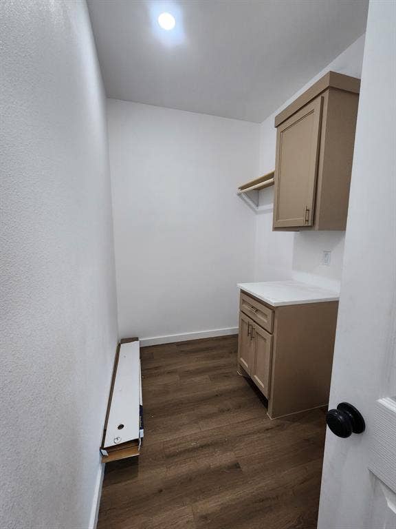 Utility space featuring wood-finish flooring, built-in cabinetry with light-toned surfaces, a countertop, and recessed ceiling lighting