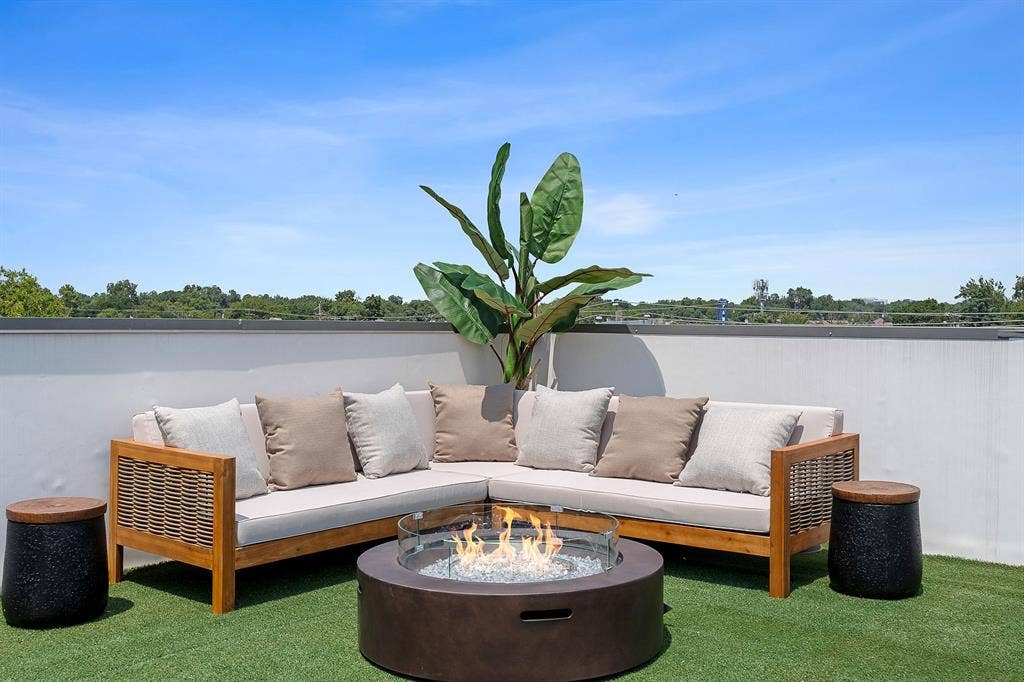 Rooftop terrace featuring synthetic grass flooring and a concrete perimeter wall