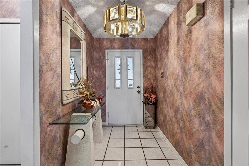 10118 Lakeview Street, Payne Springs, TX 75156 Entryway featuring tile flooring, textured wall finishes, and a tiered metallic chandelier