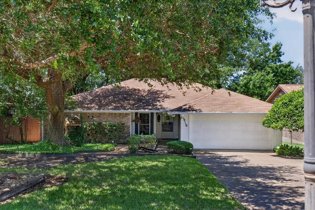 10118 Lakeview Street, Payne Springs, TX 75156 Single-story residence featuring a brick and siding exterior, multi-pitched shingle roof, attached two-car garage, and mature landscaping