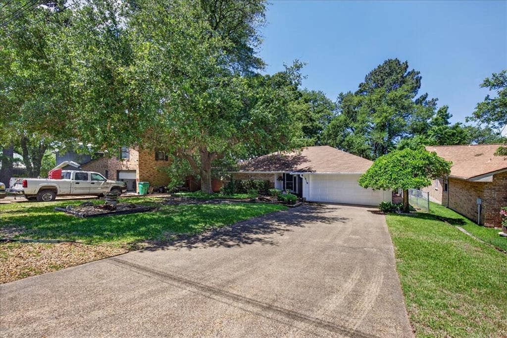 10118 Lakeview Street, Payne Springs, TX 75156 Single-story brick exterior featuring a concrete driveway, two-car garage, and mature trees