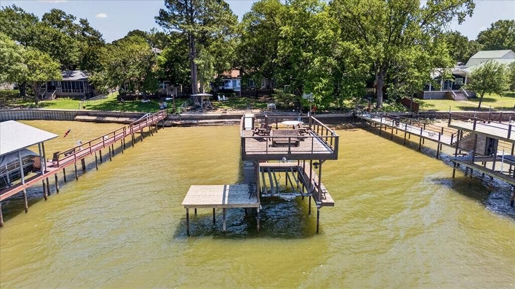10118 Lakeview Street, Payne Springs, TX 75156 Waterfront property featuring a dual-level wood dock, covered boat slip, steel bulkhead, and elevated deck platform with railing