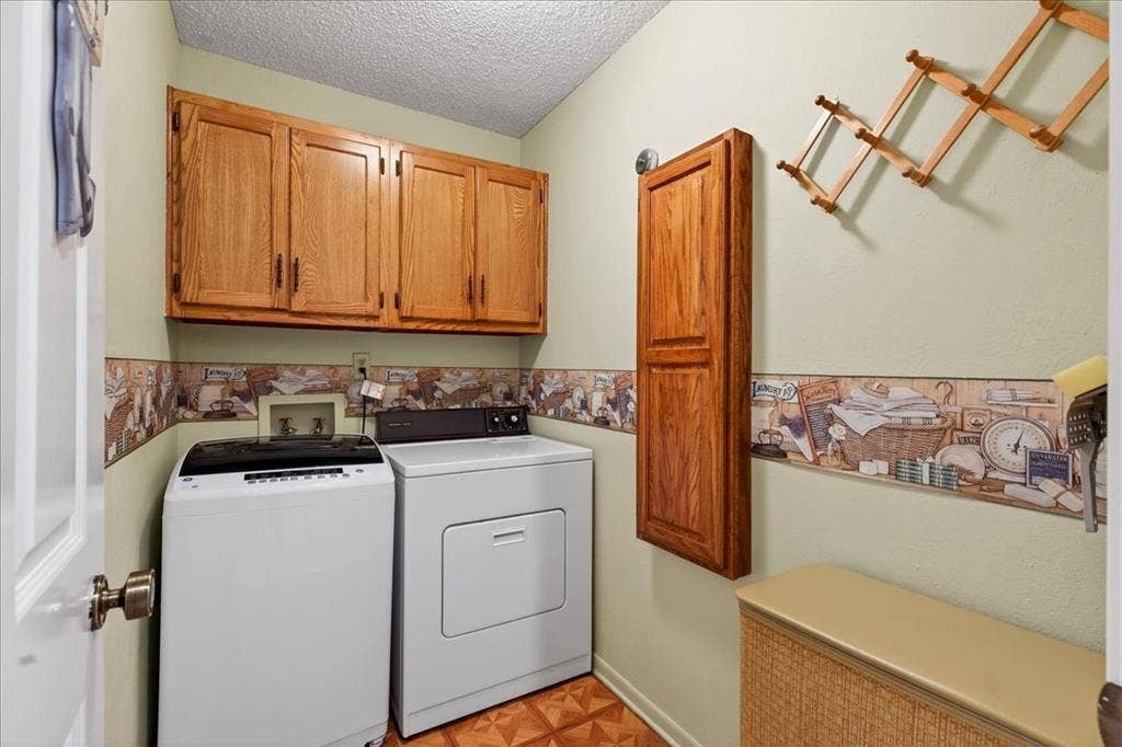 10118 Lakeview Street, Payne Springs, TX 75156 Laundry room featuring upper wood-finish cabinetry, a vertical wall-mounted wood-finish cabinet, and patterned wall border detail