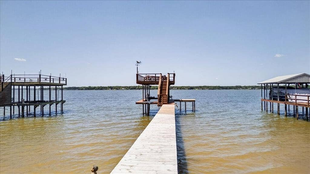 10118 Lakeview Street, Payne Springs, TX 75156 Waterfront pier featuring a multi-level wood deck, metal railing, and an integrated staircase