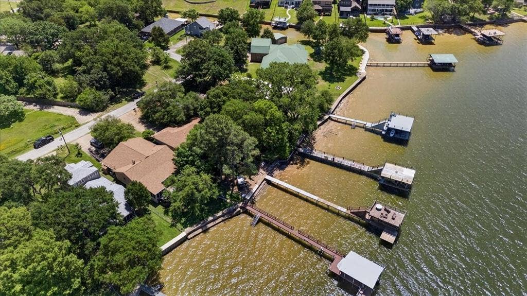 10118 Lakeview Street, Payne Springs, TX 75156 Waterfront property featuring a private boat dock, extensive shoreline, mature trees, and shingle-roof residence