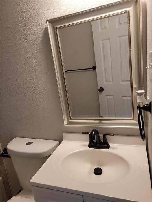 Vanity featuring an integrated sink, matte black faucet, framed wall mirror, and matte black hardware